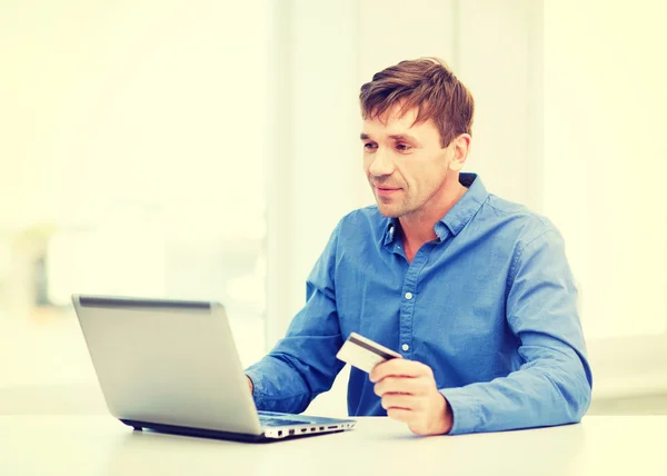 Man med laptop och kreditkort hemma — Stockfoto