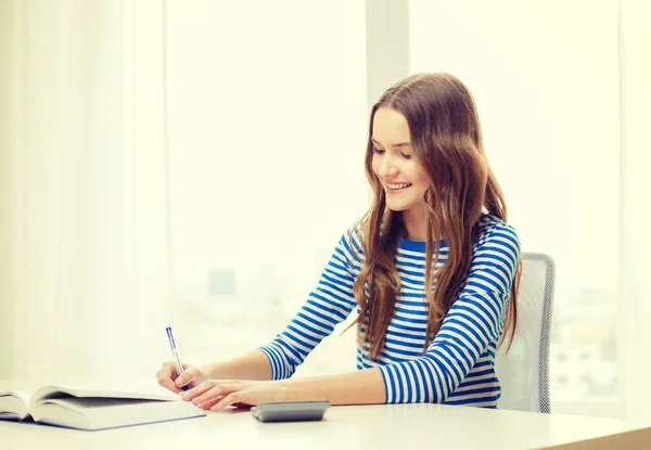 Student tjej med bok, kalkylator och bärbara — Stockfoto