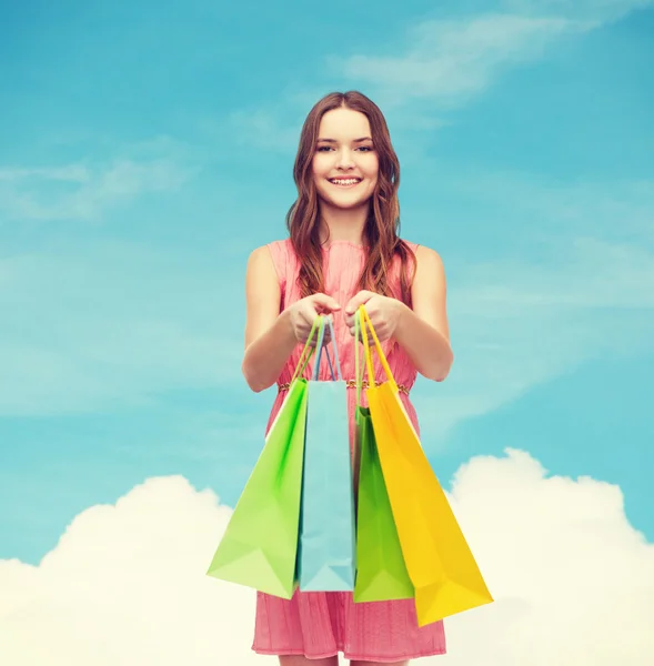 Lachende vrouw in jurk met veel shopping tassen — Stockfoto