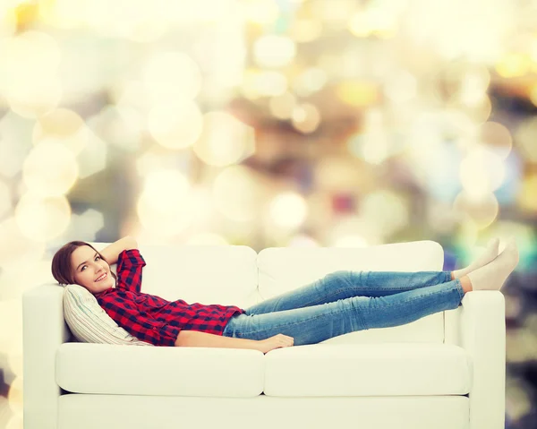 Adolescente souriante couchée sur le canapé — Photo