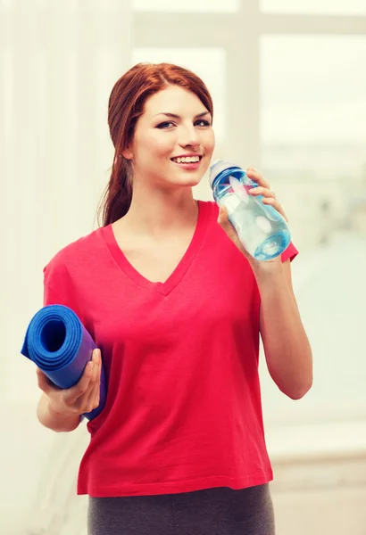 Chica sonriente con botella de agua después de hacer ejercicio — Foto de Stock