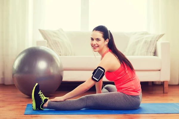 Leende flicka med armband execising hemma — Stockfoto