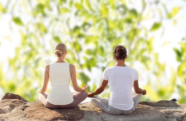 Pareja sonriente haciendo ejercicios de yoga al aire libre —  Fotos de Stock