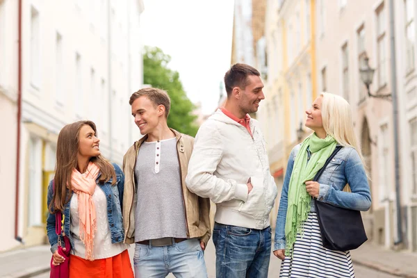 Gruppo di amici sorridenti che passeggiano in città — Foto Stock
