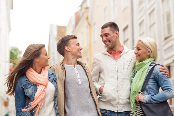 Groep lachende vrienden wandelen in de stad — Stockfoto
