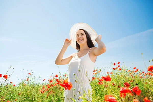 Jeune femme souriante en chapeau de paille sur champ de pavot — Photo