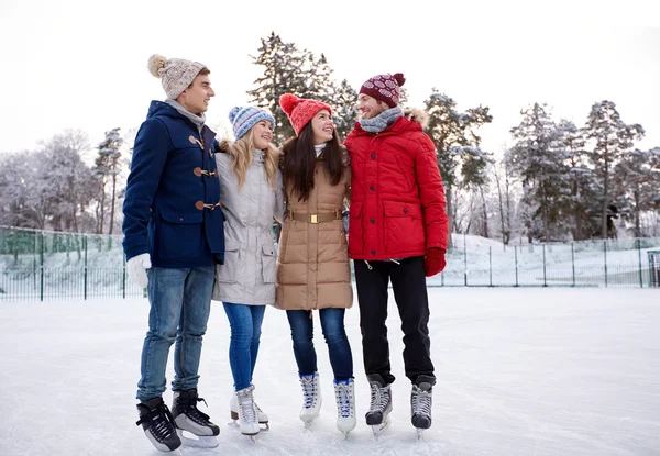 Szczęśliwy przyjaciół na łyżwach na lodowisku na zewnątrz — Zdjęcie stockowe