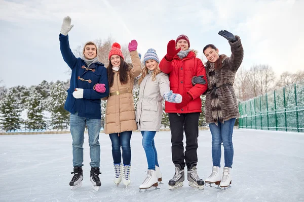 Счастливые друзья катаются на катке на открытом воздухе — стоковое фото