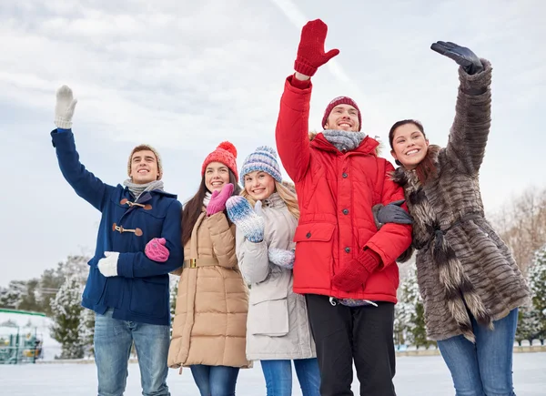 Szczęśliwy przyjaciele machanie rękami na lodowisko na zewnątrz — Zdjęcie stockowe