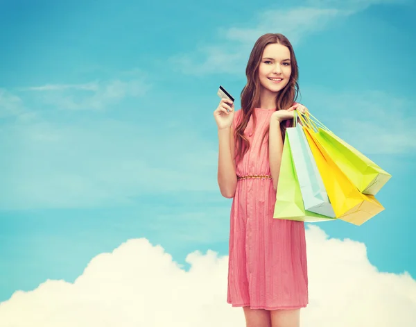 Lachende vrouw in jurk met veel shopping tassen — Stockfoto