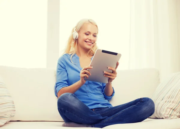 Mujer con tablet PC y auriculares en casa —  Fotos de Stock