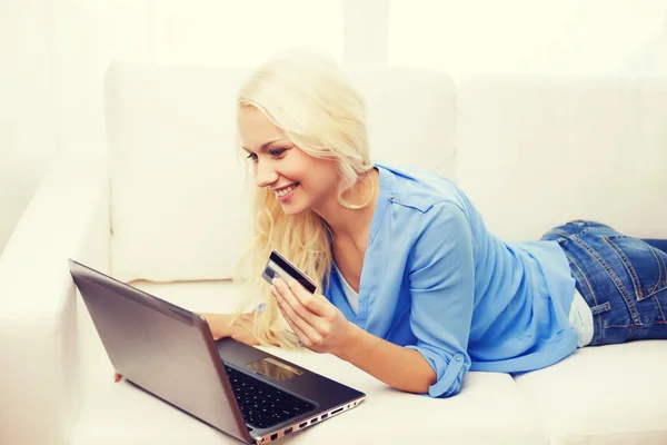 Mulher sorridente com computador portátil e cartão de crédito — Fotografia de Stock