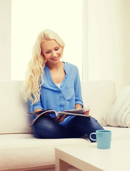 Kvinna med kopp kaffe, läsa tidningen hemma — Stockfoto