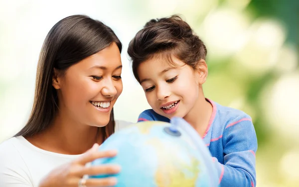 Glückliche Mutter und Tochter mit Globus — Stockfoto