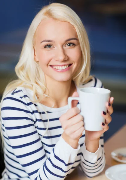 Happy young woman drinking tea or coffee — Stock Photo, Image