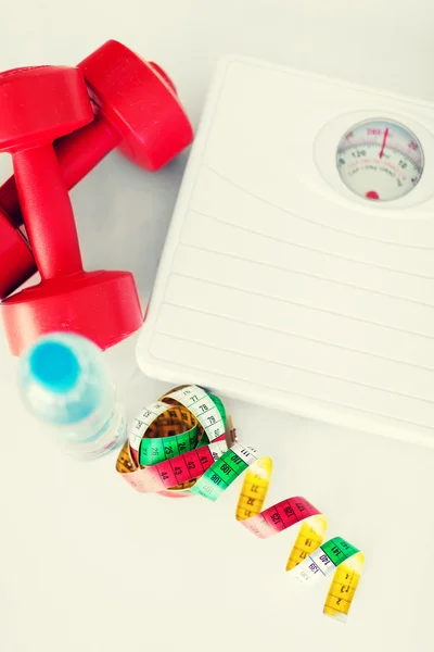 Scales, dumbbells, bottle of water, measuring tape — Stock Photo, Image