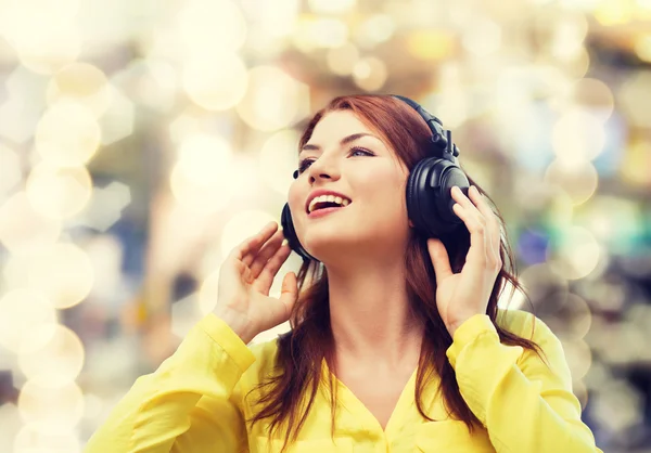 Sonriente chica joven en los auriculares en casa —  Fotos de Stock