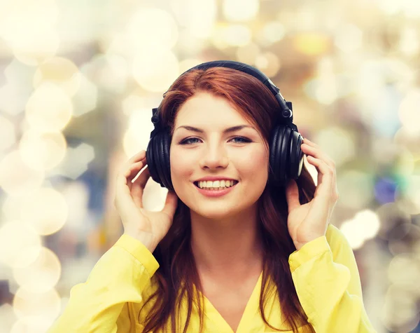 Sorrindo menina em fones de ouvido em casa — Fotografia de Stock