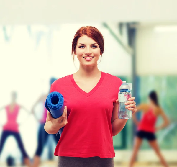 Smiling girl with bottle of water after exercising — Stock Photo, Image