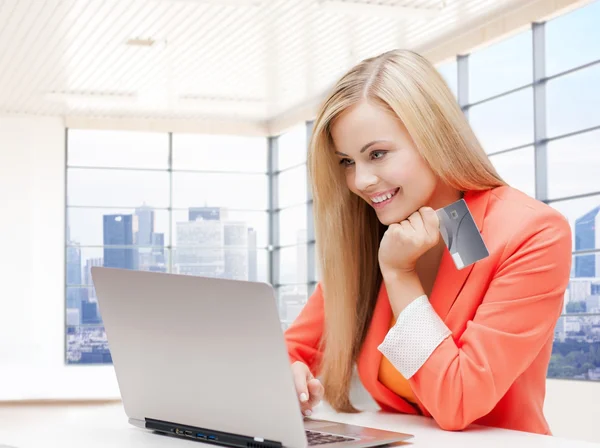 Mulher sorridente com computador portátil e cartão de crédito — Fotografia de Stock