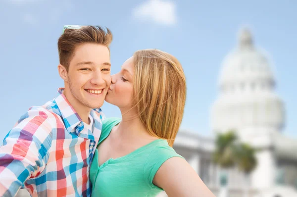 Couple kissing and taking selfie over white house — Stock Photo, Image