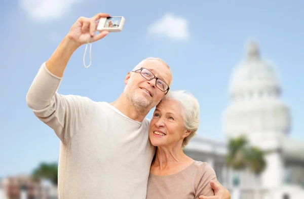 Coppia anziana con macchina fotografica sopra la casa bianca — Foto Stock