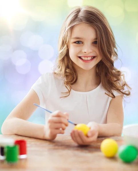 Happy girl with brush coloring easter eggs — Stock Photo, Image