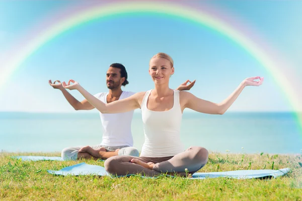 Çift gülümseyen açık havada yapım yoga egzersizleri — Stok fotoğraf