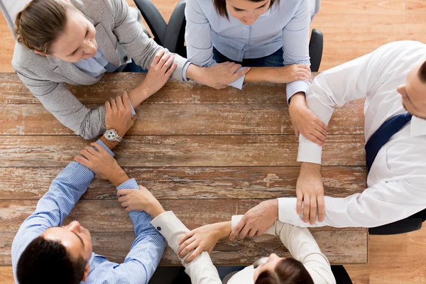 Närbild på business team håller hand vid bordet — Stockfoto