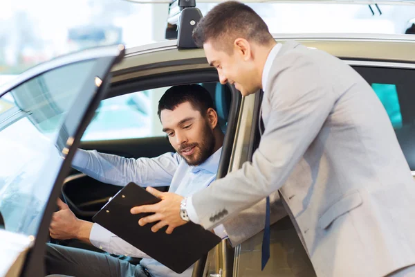 Happy man with car dealer in auto show or salon — Stock Photo, Image
