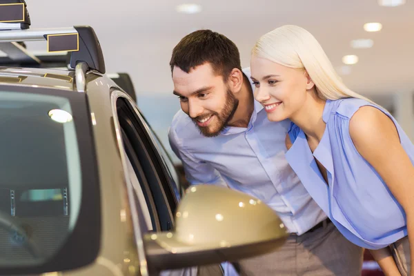 Happy couple buying car in auto show or salon — Stock Photo, Image