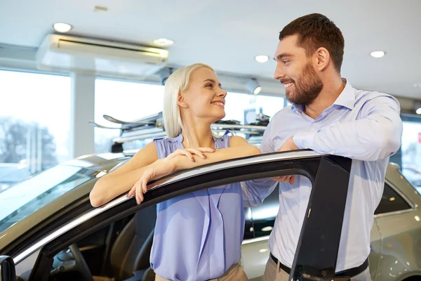 Feliz pareja comprando coche en auto show o salón —  Fotos de Stock