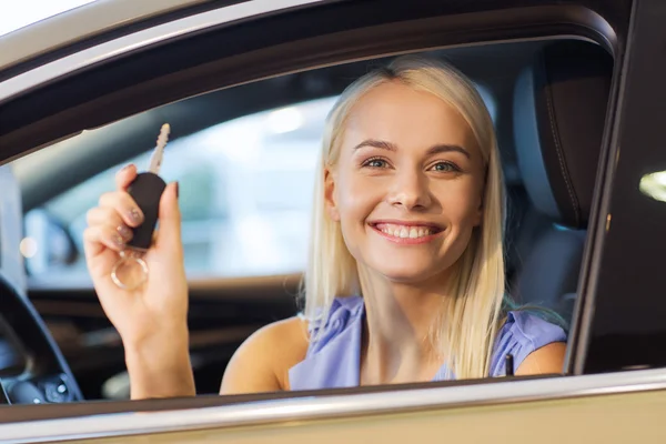 Happy woman getting car key in auto show or salon — Stock Photo, Image