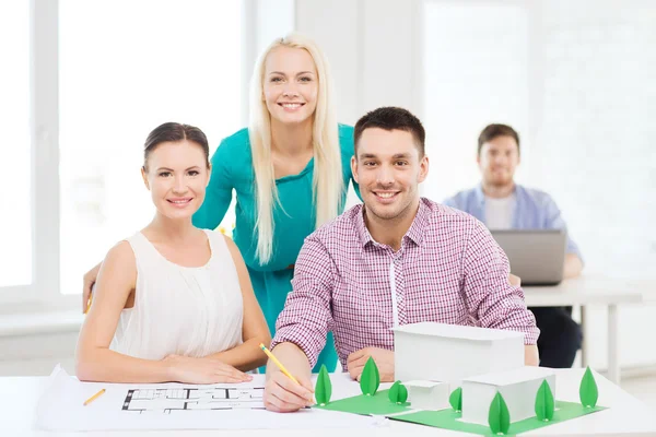 Arquitectos sonrientes trabajando en la oficina — Foto de Stock