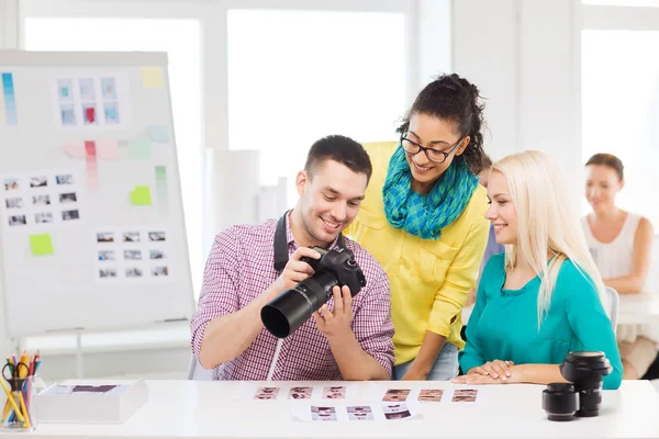 Usměvavý tým s fotokamery pracující v kanceláři — Stock fotografie