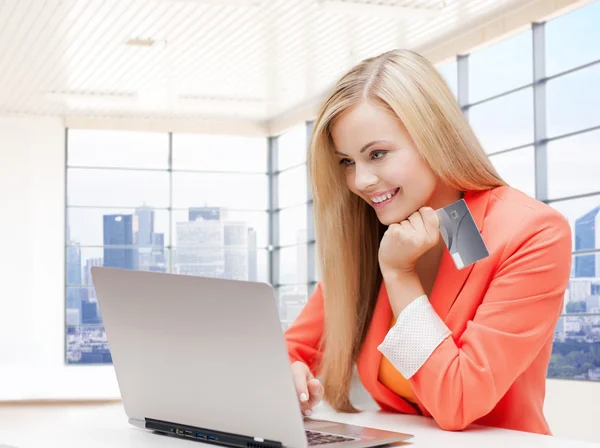 Lächelnde Frau mit Laptop und Kreditkarte Stockbild
