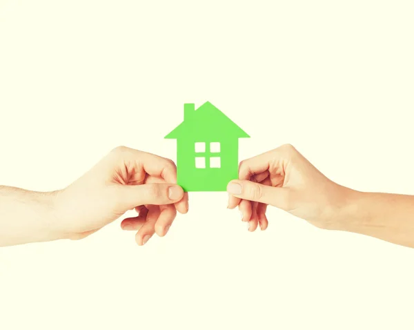 Couple hands holding green house — Stock Photo, Image