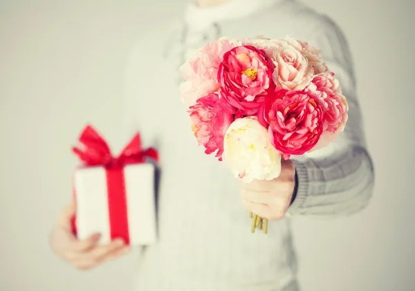Hombre sosteniendo ramo de flores y caja de regalo — Foto de Stock