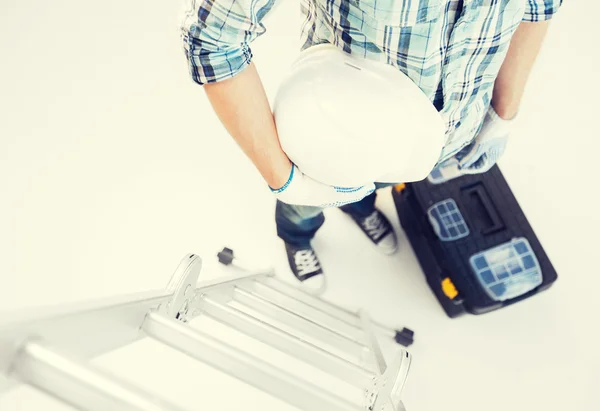 Hombre con escalera, casco y caja de herramientas — Foto de Stock