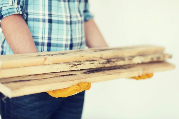 Close-up van de man in handschoenen met houten planken — Stockfoto