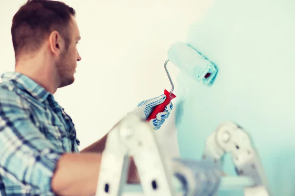 Primer plano de macho en guantes sosteniendo rodillo de pintura — Foto de Stock