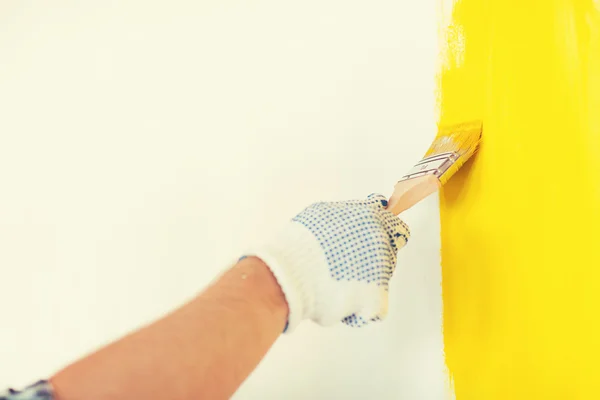 Close up of male in gloves holding paintbrush — Stock Photo, Image