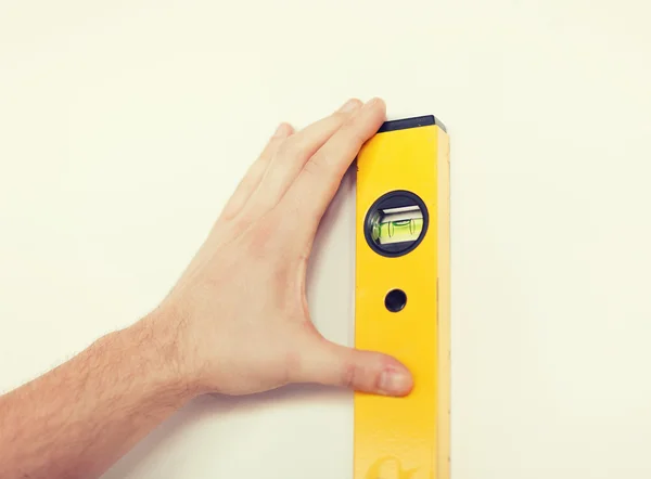 Close up of male with spirit level mesuring wall — Stock Photo, Image