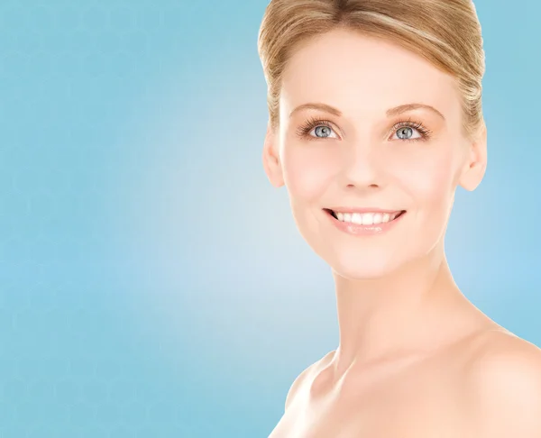 Close up of smiling woman over blue background — Stock Photo, Image