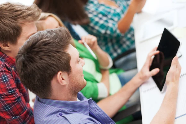 Studenten kijken naar tablet pc op school — Stockfoto