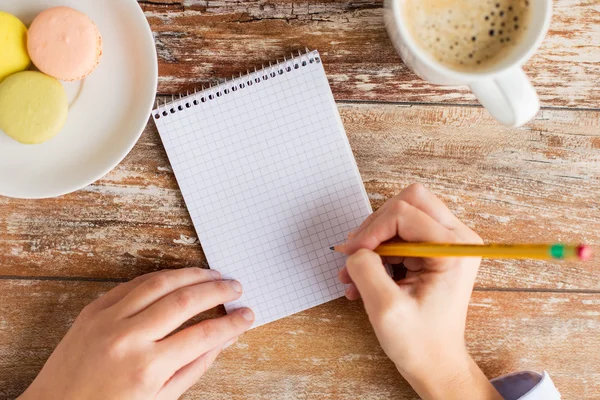 Close up of hands, notebook, coffee and cookies — Stock Photo, Image