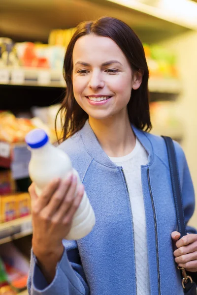 Ευτυχισμένη γυναίκα, κρατώντας το μπουκάλι γάλα στην αγορά — Φωτογραφία Αρχείου