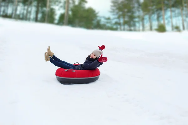 Щаслива дівчина-підліток ковзає по сніговій трубі — стокове фото