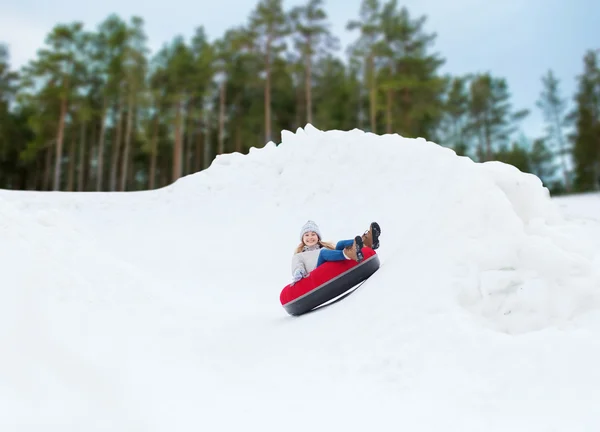 Menina adolescente feliz deslizando para baixo no tubo de neve — Fotografia de Stock