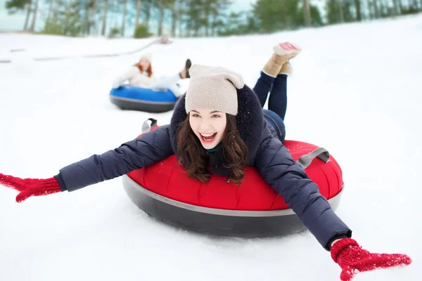 Grupo de amigos felizes deslizando para baixo em tubos de neve — Fotografia de Stock